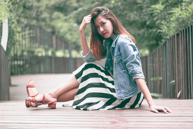 A woman sitting on a park bridge