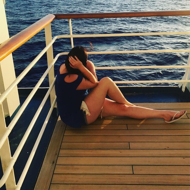 Photo woman sitting on pier over sea