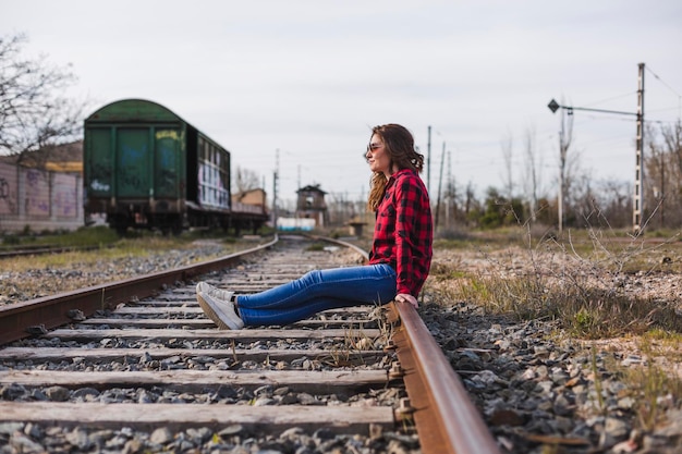 Photo woman sitting on railroad track