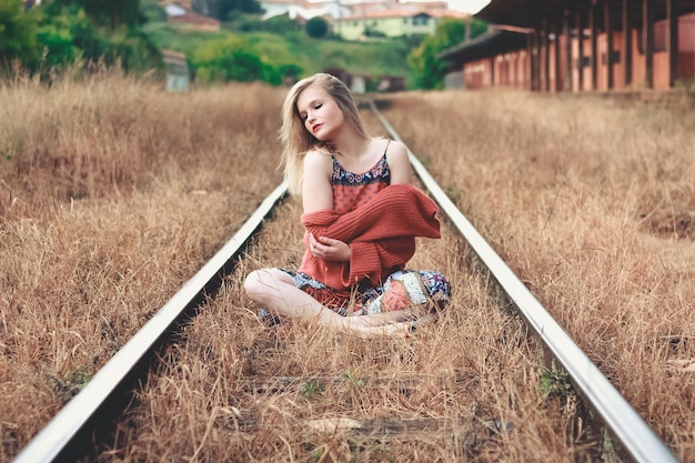 Photo woman sitting on railroad track