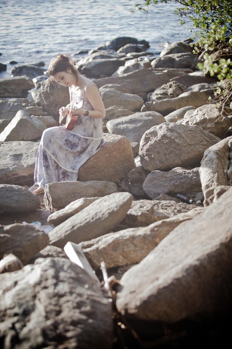 Photo woman sitting on rock at beach