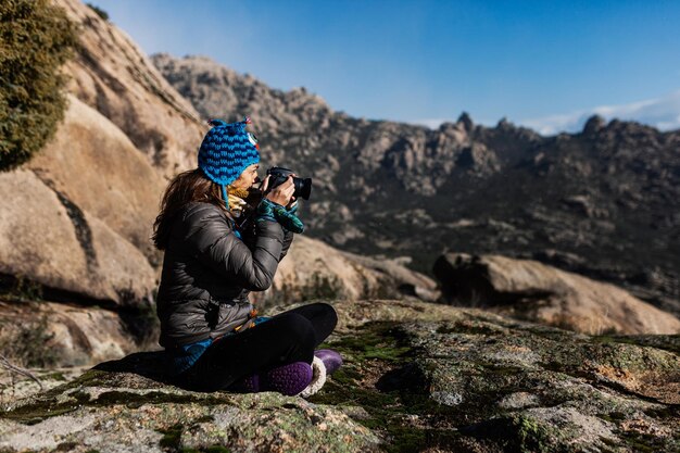 Foto donna seduta su una roccia