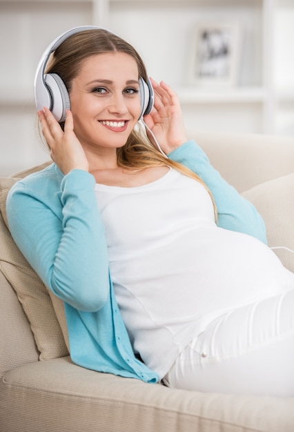 Woman sitting at sofa and enjoying the music.