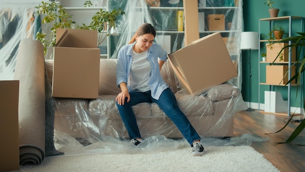 Woman sitting on the sofa feeling pain at the shoulder and neck