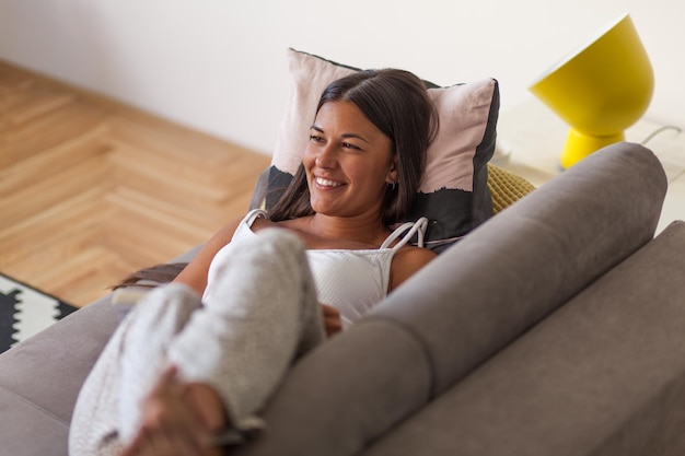 Photo woman sitting on sofa at home