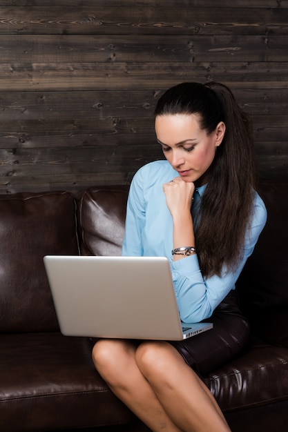 Woman sitting on the sofa and using laptop