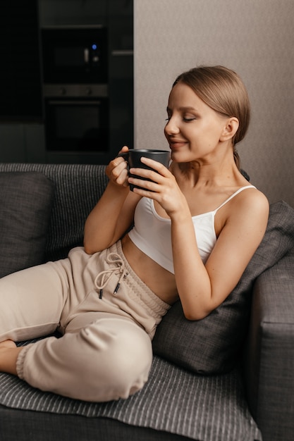 Woman sitting on the sofa with a mug of tea