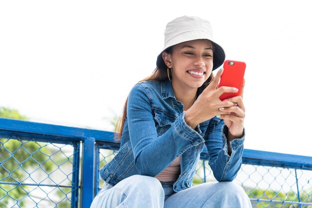 階段に座ってスマートフォンでテキストメッセージを送信する女性