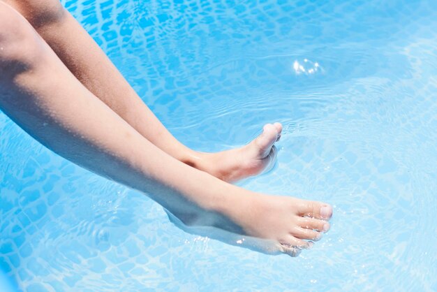 A woman sitting in a swimming pool with her feet