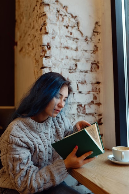 Photo woman sitting on table by window