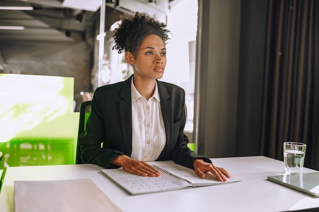 Woman sitting at table touching notebook