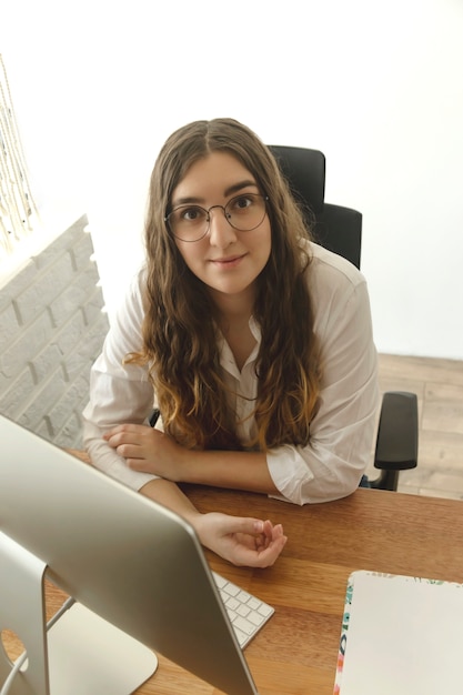 A woman sitting at a table using computer. Home office concept.