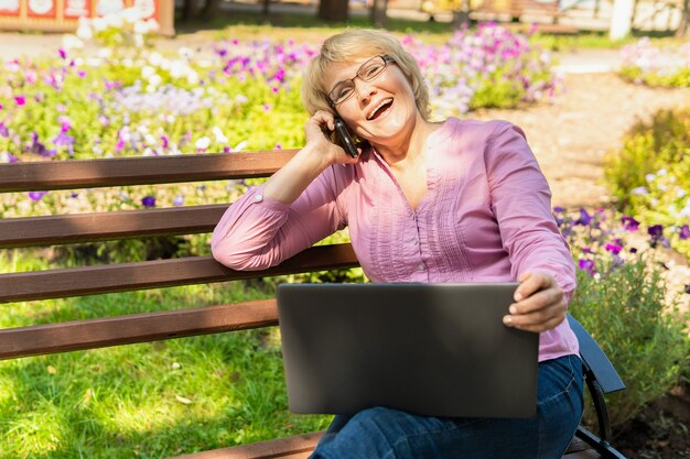 A woman sitting at a table with a cup of tea and a laptop working in a cafe