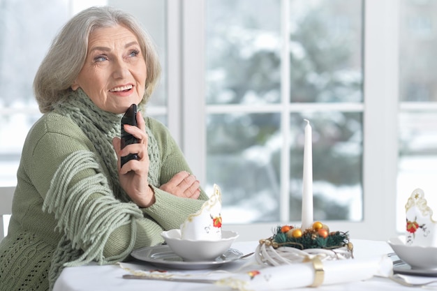 Woman sitting at table with phone