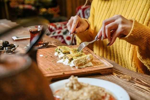 Foto donna seduta a tavola con un piatto di cibo