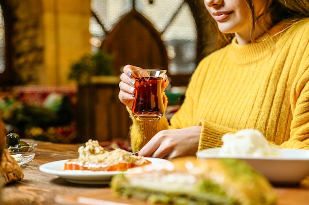 食事 の 皿 を 持っ て テーブル に 座っ て いる 女性