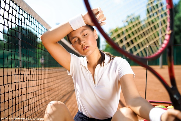 A woman sitting on the tennis court