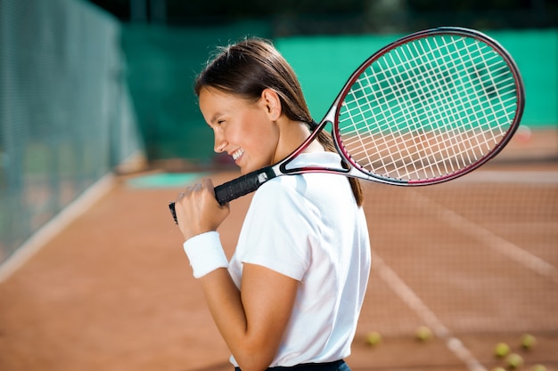 Una donna seduta sul campo da tennis