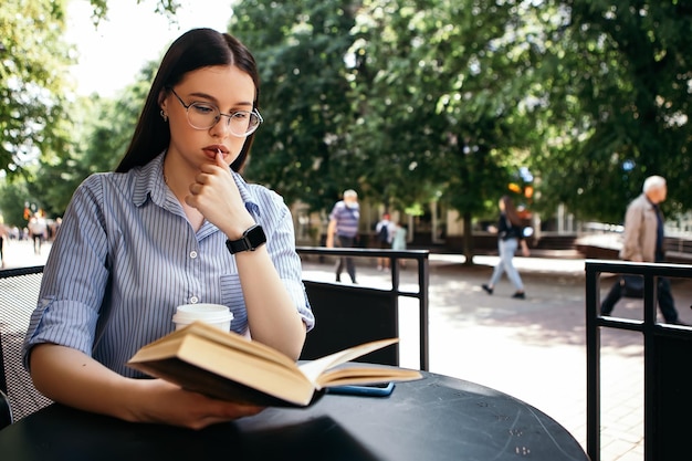 テラスに座って本を読んでいる女性