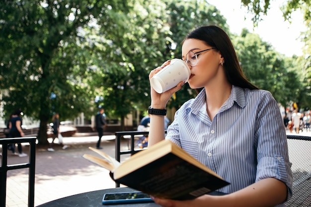 テラスに座って本を読んでいる女性