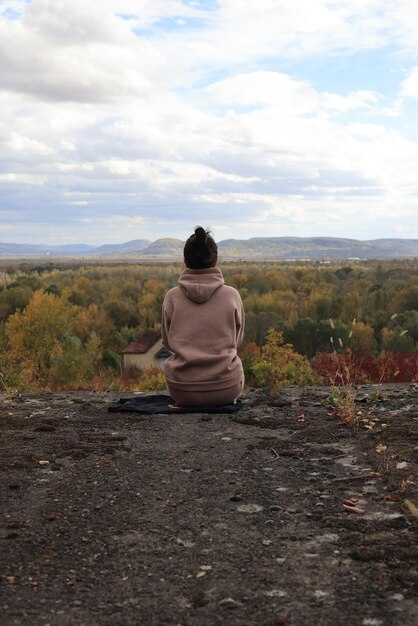 woman sitting on the top of a rock and looking to the side