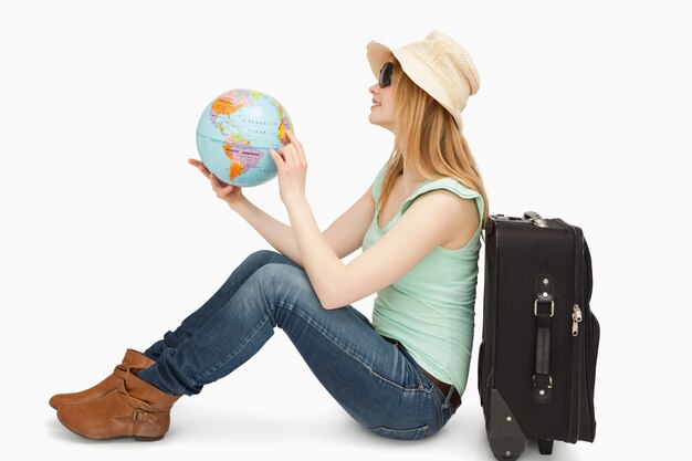 Photo woman sitting while holding a world globe