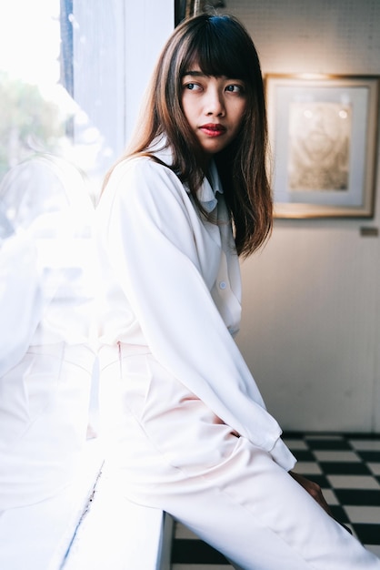 一個女人坐在家裡的窗<unk>上