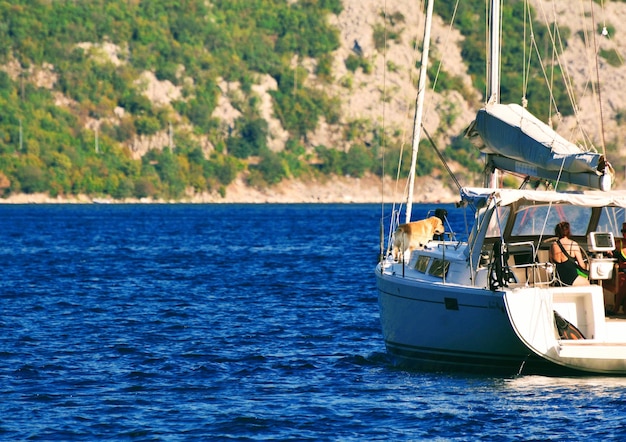 Photo woman sitting with dog on boat in sea