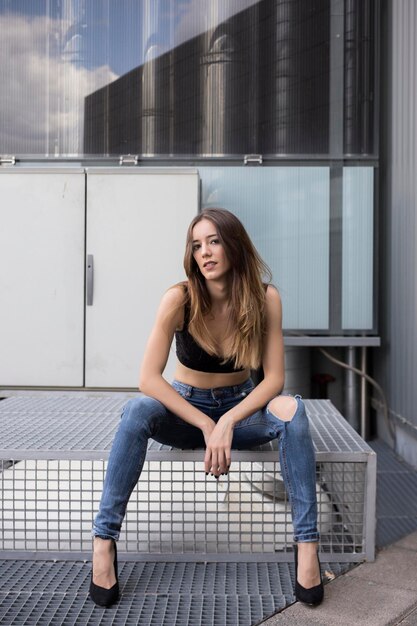 Photo woman sitting with fashion pose on industrial site