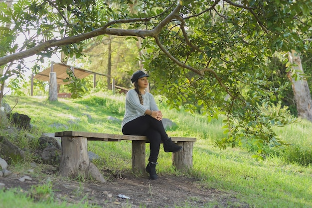 Woman sitting on a wooden bench admiring nature Portrait of woman enjoying nature