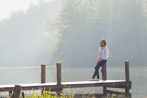 Woman sitting on a wooden bridge