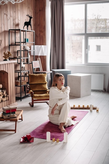 Foto donna seduta sul pavimento di legno a casa