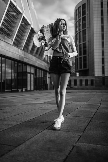 Woman on a skateboard in the city. beautiful contrasting black\
and white photo of a woman riding