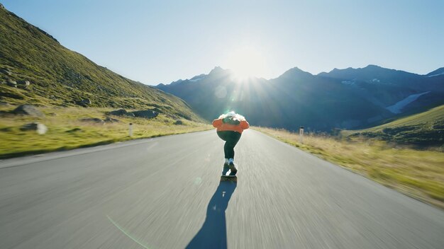 Woman skateboarding and making tricks between the curves on a mountain pass