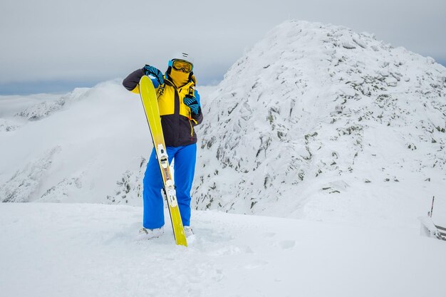 Woman skier posing on the top of snowed mountain copy space