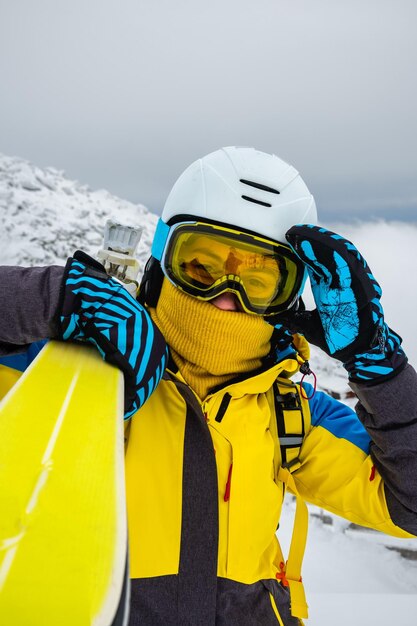 雪が降った山の頂上でポーズをとる女性スキーヤー