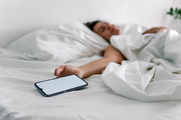 Woman sleeping in bed phone in her hand