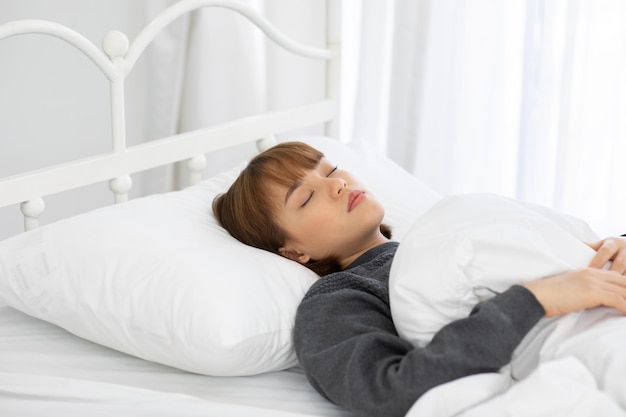 Foto donna che dorme sul letto con una coperta