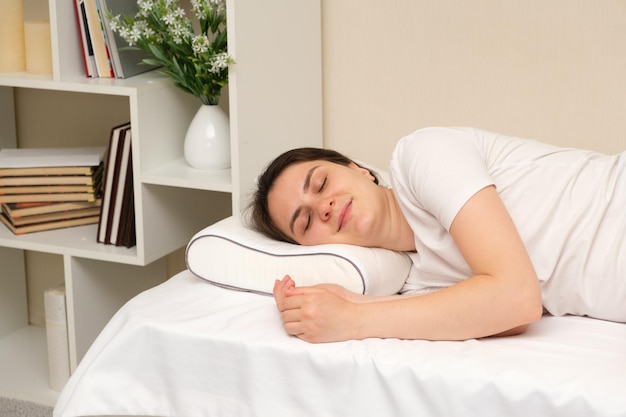 A woman sleeps on an orthopedic pillow made of memory foam
