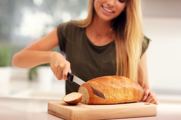 woman slicing loaf of bread