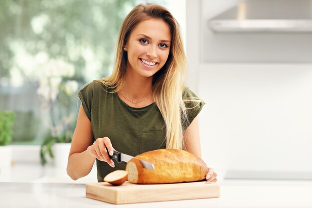 woman slicing loaf of bread