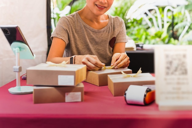 Woman small business owner packing box on table delivery to customer