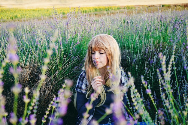 woman smelling flower amidst plants