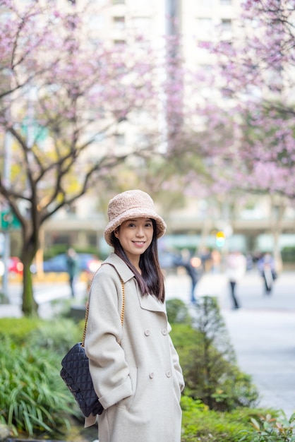 都市の背景でカメラに笑顔を浮かべる女性