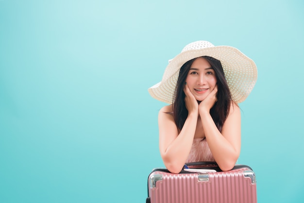 Woman smile in summer trip to travel with hat on suitcase bag