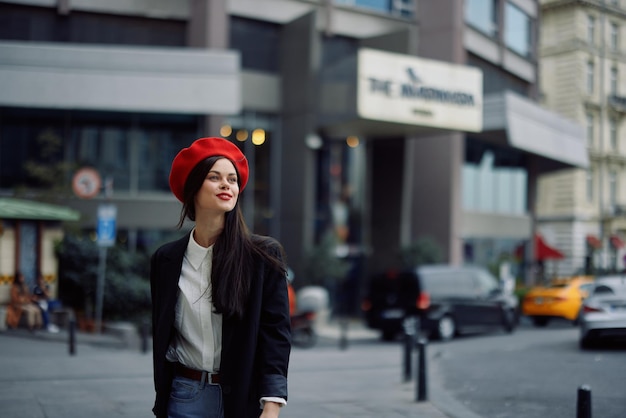 Woman smile with teeth tourist walks walks in the city on the background of office buildings stylish fashionable clothes and makeup spring walk travel