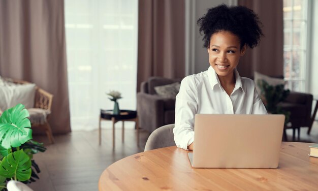 Photo the woman smiles and prints a message to the client by mail the influencer works at home online