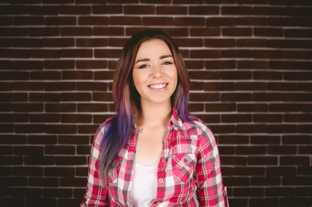 Woman smiling against brick wall