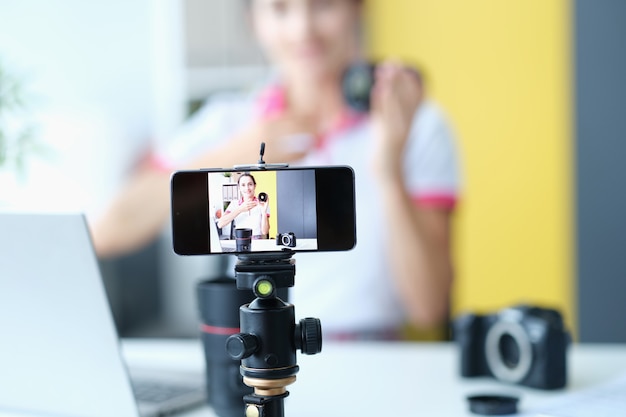 Woman smiling at camera while recording lens review for followers influencer on social media