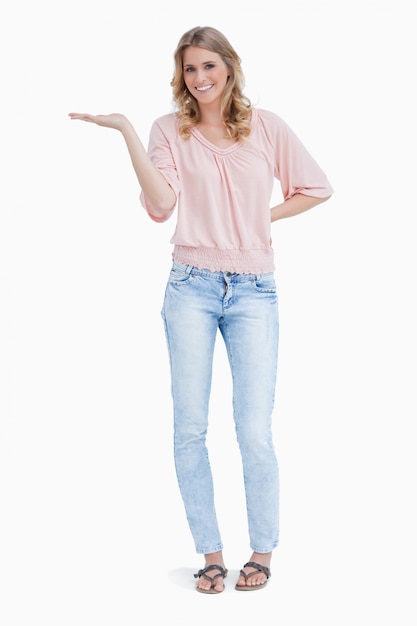 Woman smiling at the camera with the palm of her hand held up flat